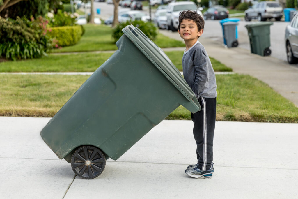 child with residential trash can