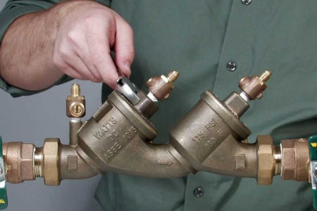 man working on backflow preventer