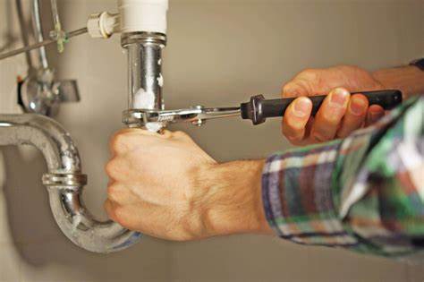 man fixing leaking pipe