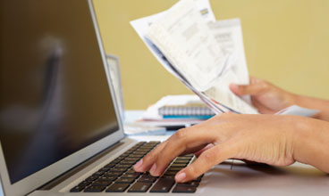 person paying bills on a computer